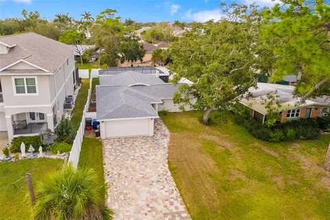 a aerial view of a house with swimming pool and large trees