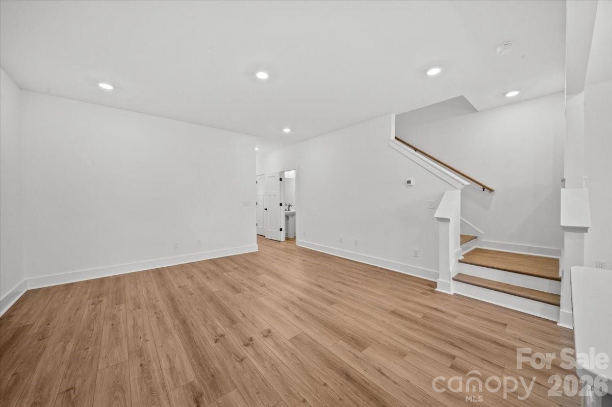 49 Moon Hvn Way Arden, NC 28704 - Photo 11 of 30 an empty room with wooden floor and stairs