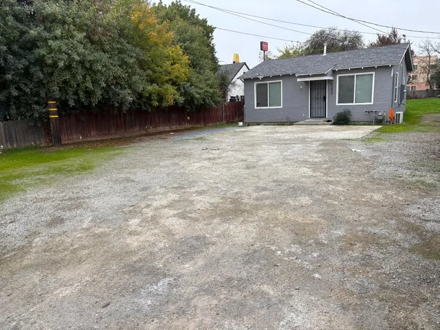 a front view of a house with a garden and trees