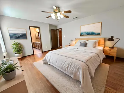 a spacious bedroom with a bed and a chandelier