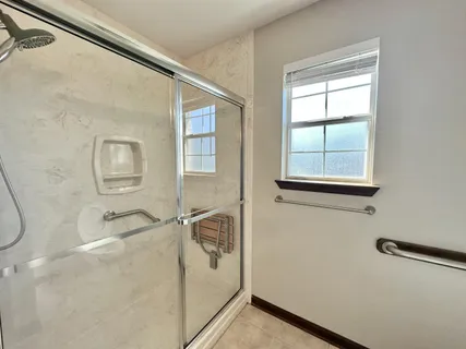 a bathroom with a glass shower door and a mirror