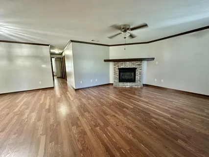 a view of a livingroom with wooden floor and a ceiling fan