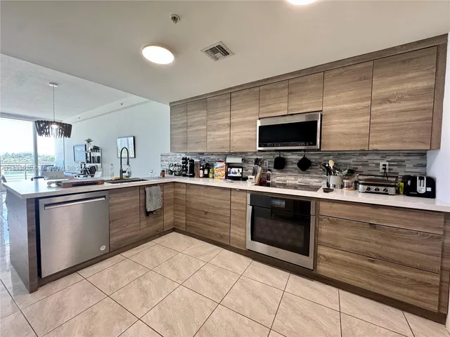 a kitchen with stainless steel appliances granite countertop a stove a sink and a microwave