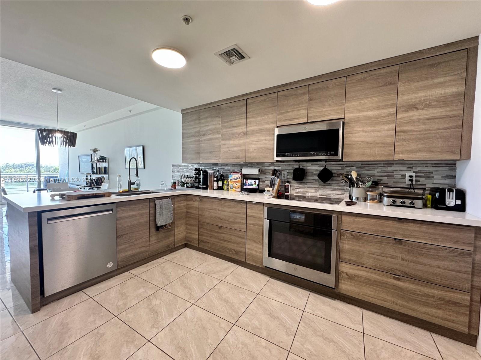 a kitchen with stainless steel appliances granite countertop a stove a sink and a microwave