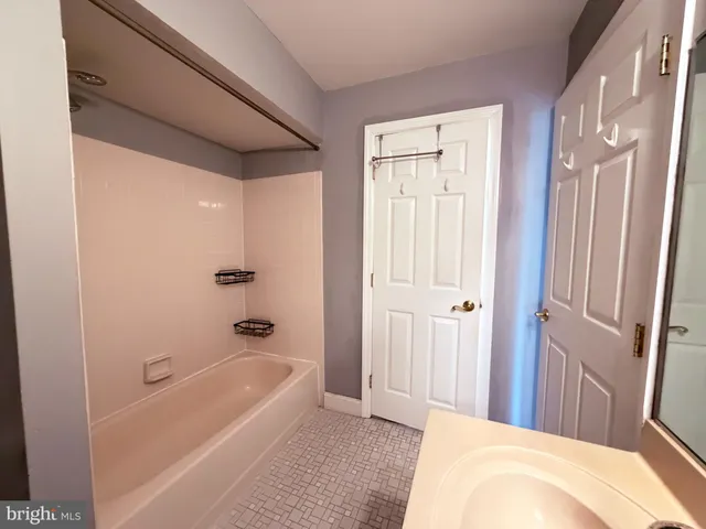 a bathroom with a tub shower and sink