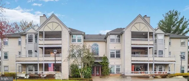 a front view of a residential apartment building with a yard and garage