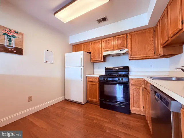 a kitchen with stainless steel appliances granite countertop a refrigerator a stove and a sink