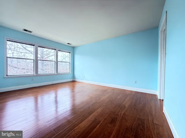 wooden floor in an empty room with a window