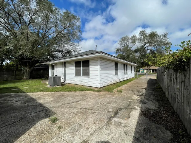 a view of a house with backyard and trees