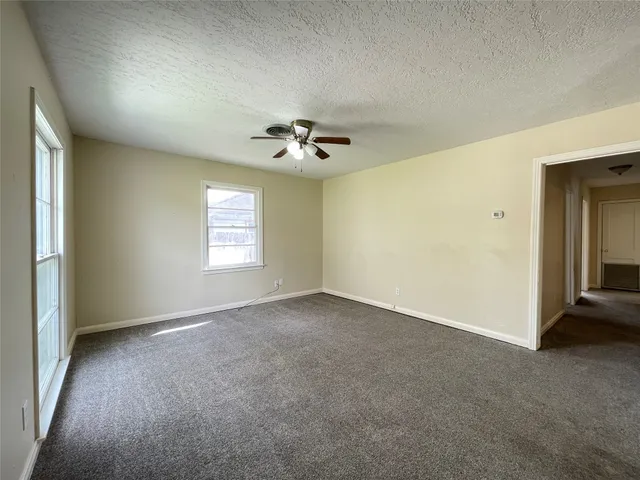 an empty room with a window and a ceiling fan
