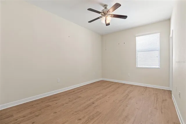 an empty room with fan and entrance