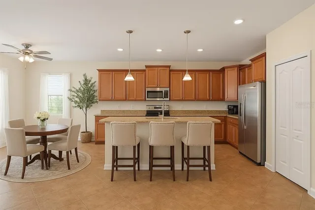 a kitchen with a refrigerator and chairs