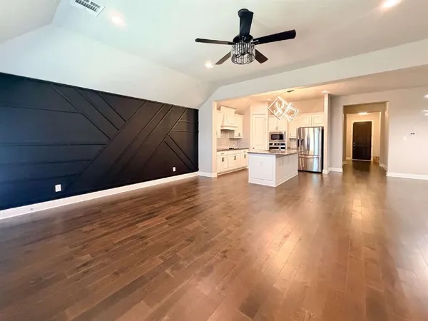 a view of a kitchen with a ceiling fan hardwood floor and a ceiling fan