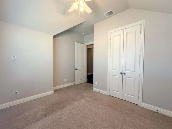a view of an empty room with closet and a bathroom