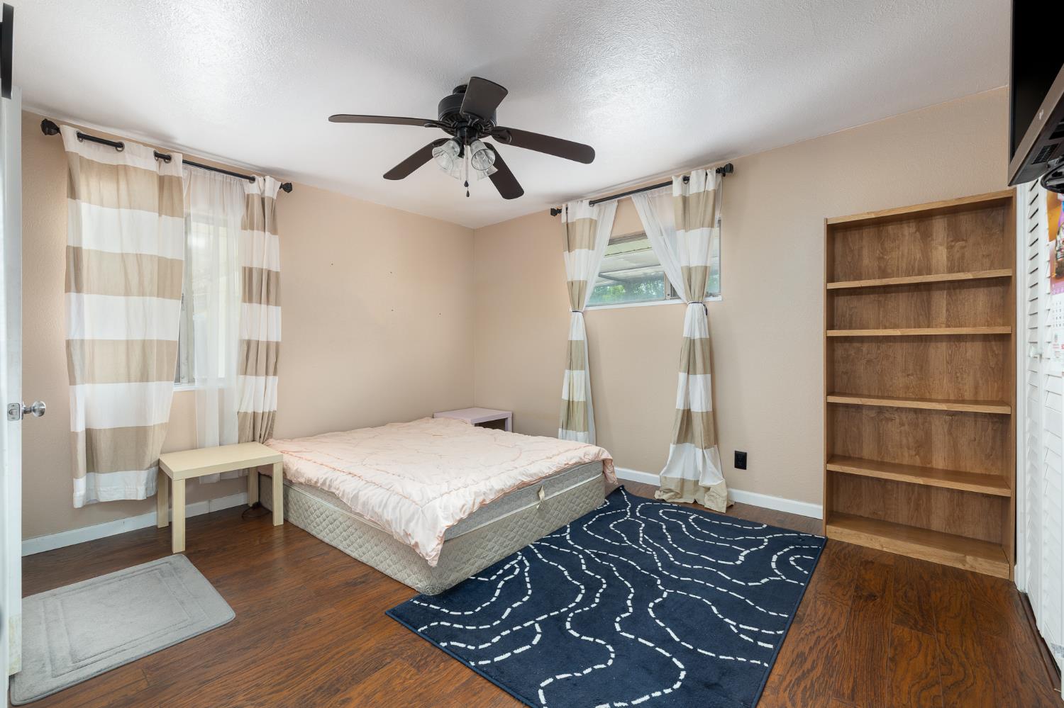 4683 North Angus Street Fresno, CA 93726 - Photo 17 of 27 a bedroom with a bed and a chandelier