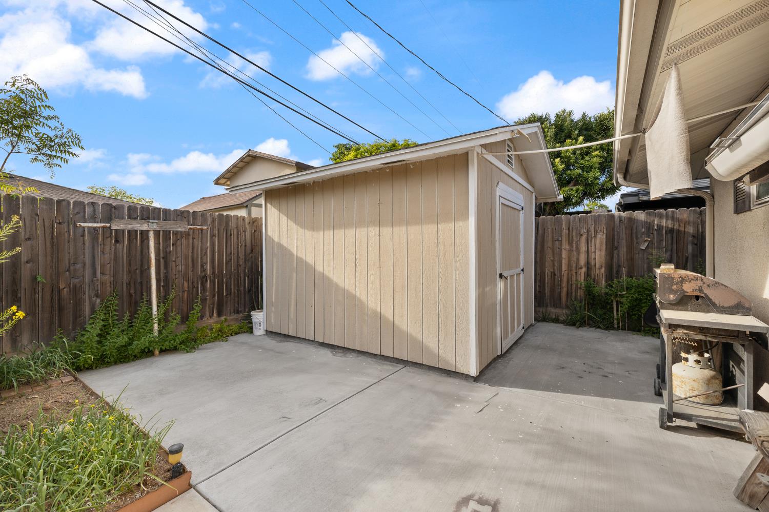 4683 North Angus Street Fresno, CA 93726 - Photo 27 of 27 a view of backyard with small cabin and wooden fencing
