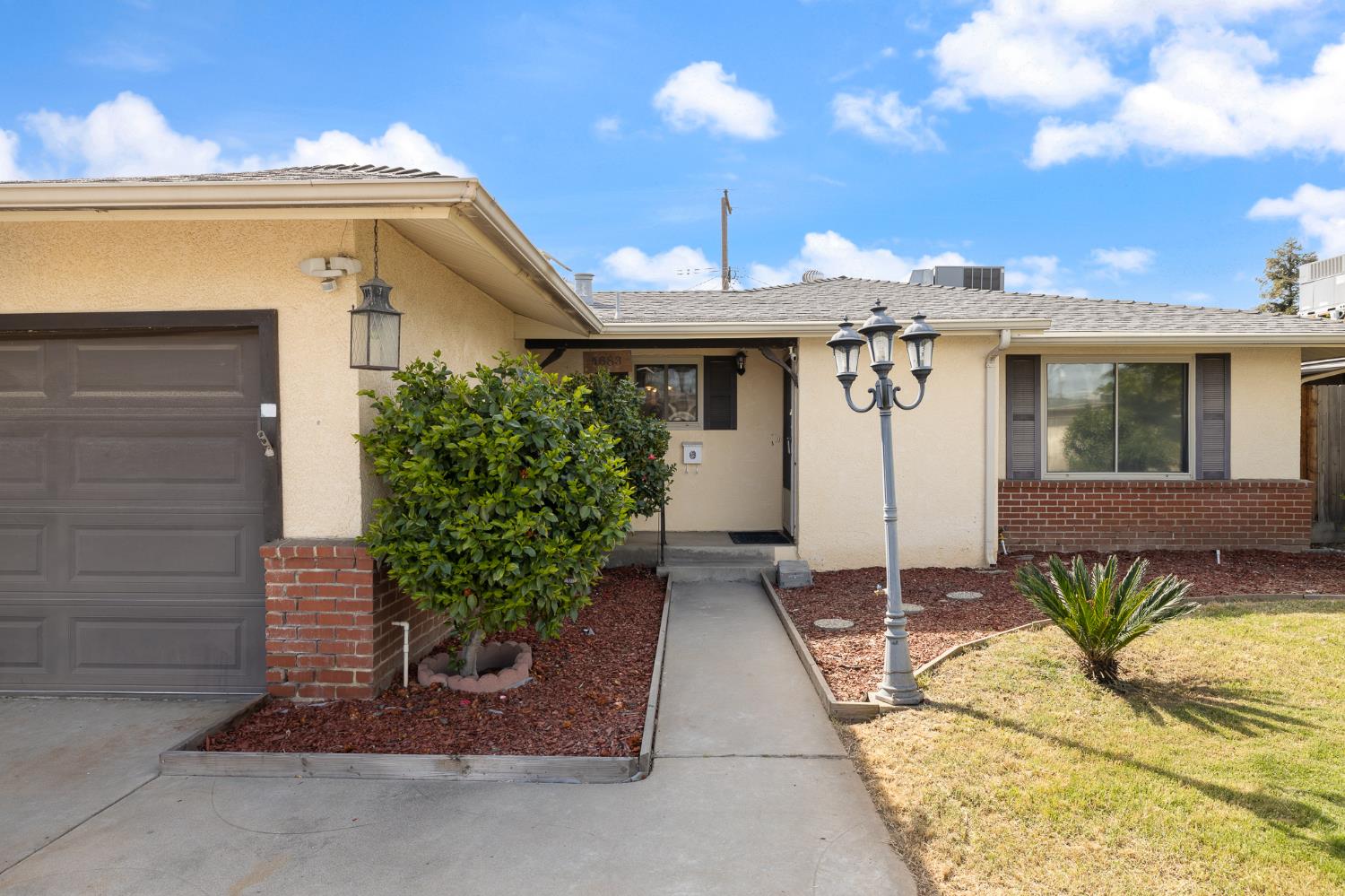 4683 North Angus Street Fresno, CA 93726 - Photo 3 of 27 a front view of a house with a yard and potted plants