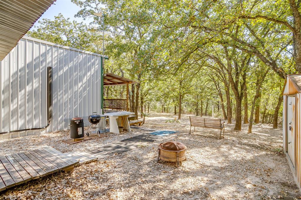 436 Luke Road Springtown, TX 76082 - Photo 28 of 39 View of patio / terrace with a fire pit, a deck, and an outdoor structure