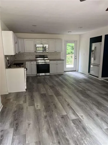 a kitchen with granite countertop a stove top oven and cabinets