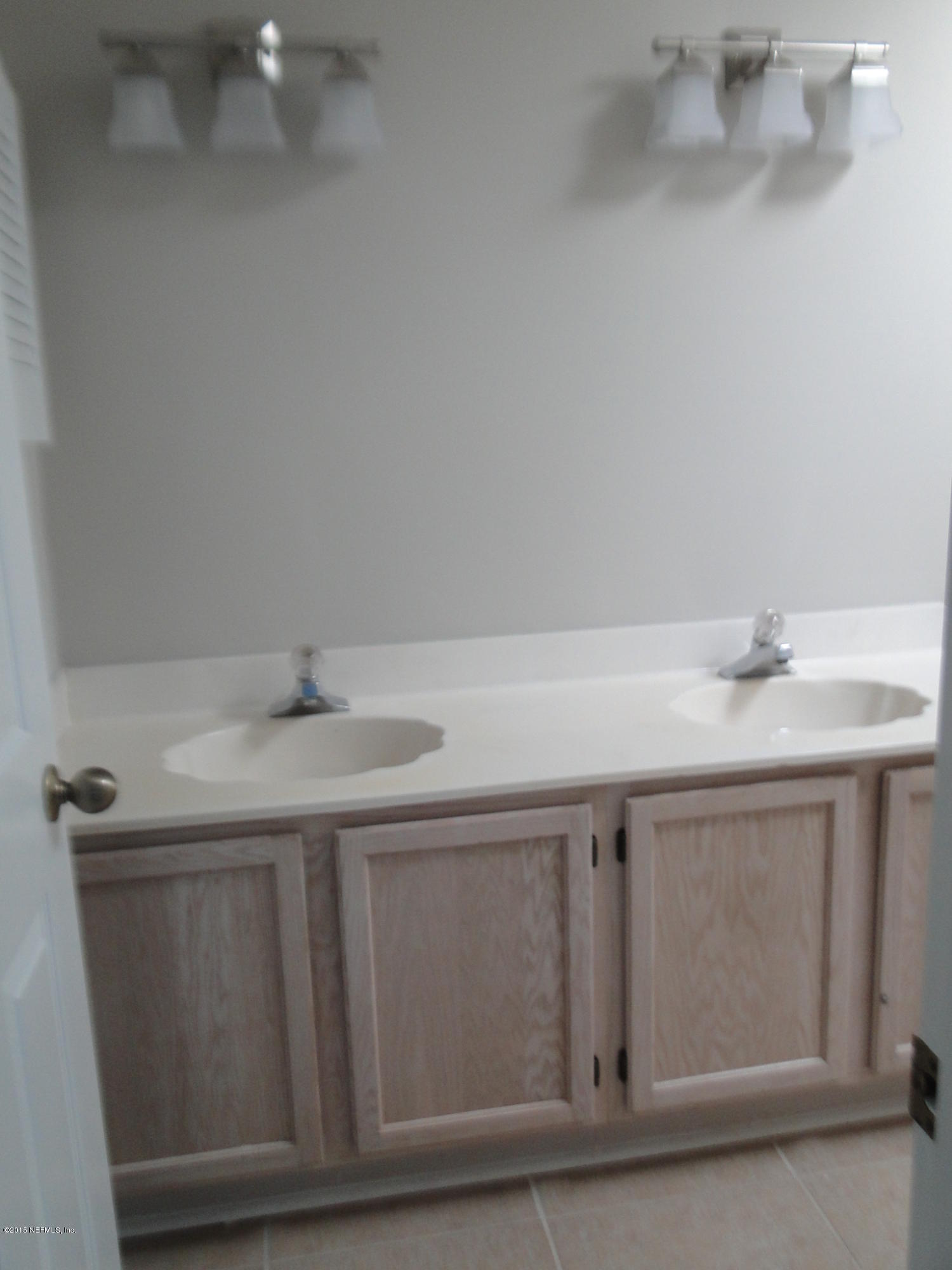 5496 Spring Brook Road Jacksonville, FL 32277 - Photo 21 of 25 a bathroom with a sink and cabinets