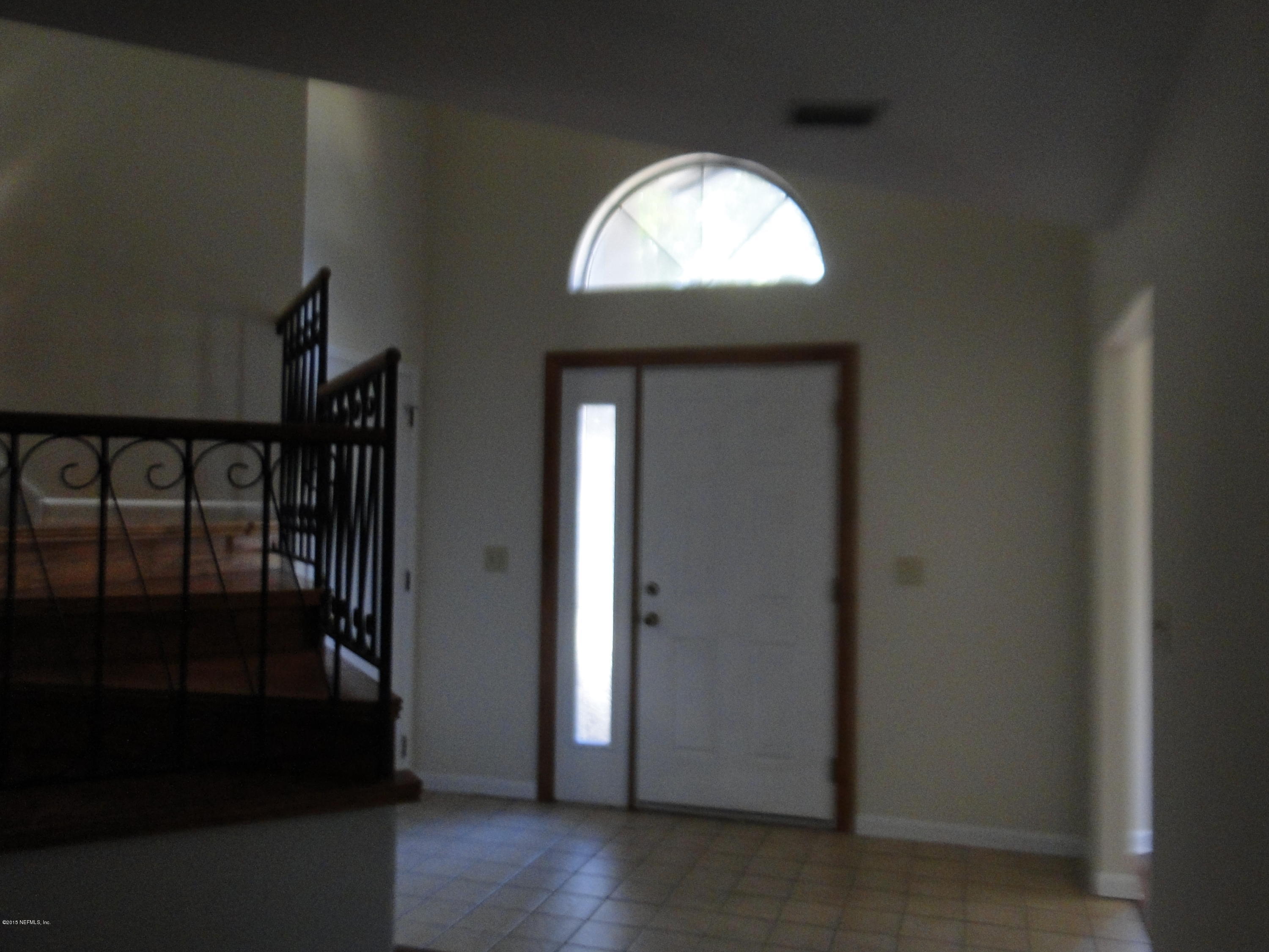 5496 Spring Brook Road Jacksonville, FL 32277 - Photo 3 of 25 an empty room with wooden floor cabinet and entryway