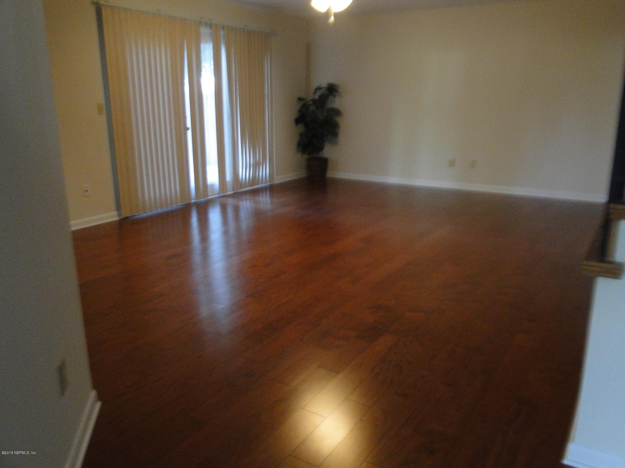 5496 Spring Brook Road Jacksonville, FL 32277 - Photo 5 of 25 an empty room with wooden floor and windows
