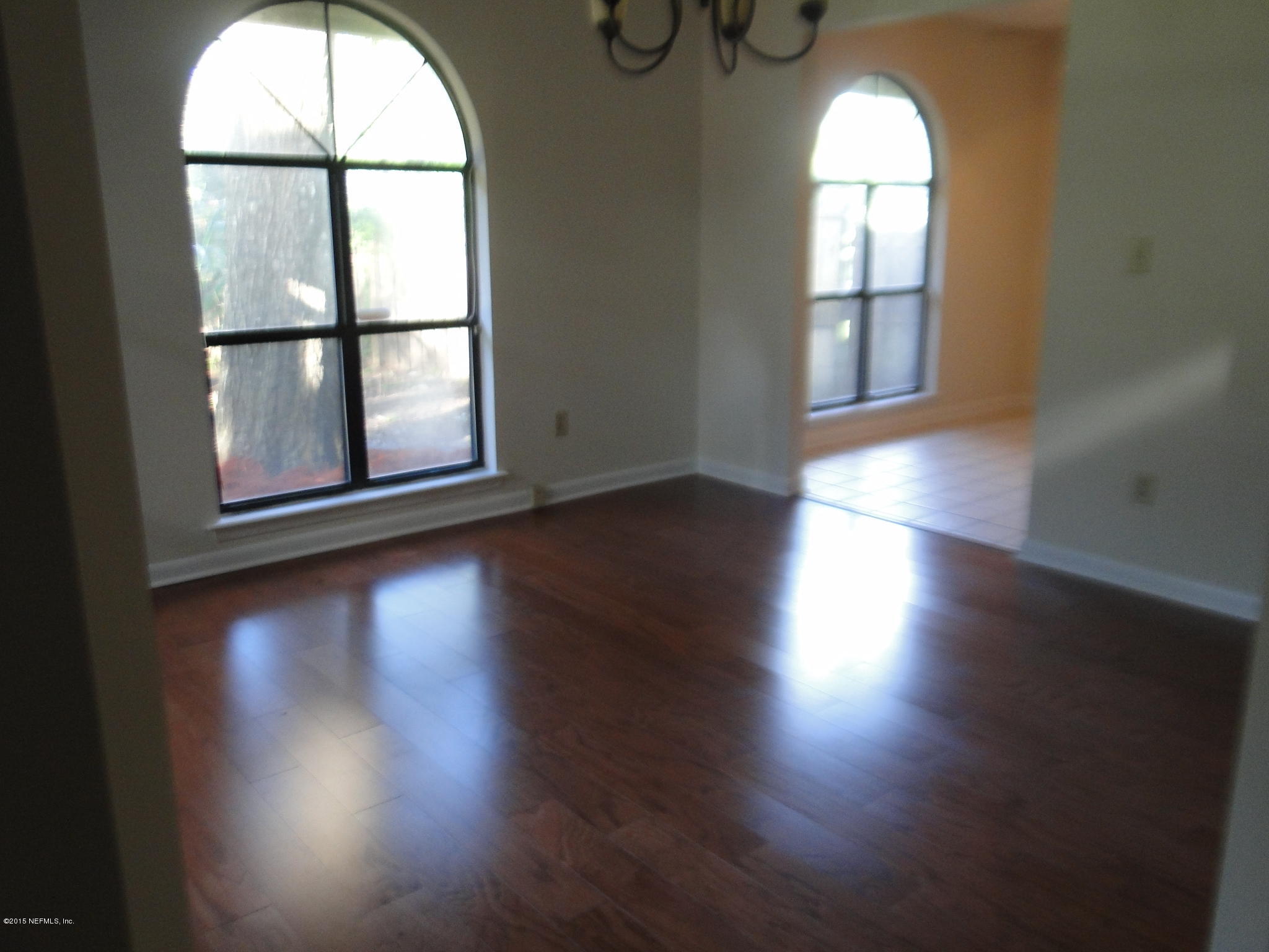 5496 Spring Brook Road Jacksonville, FL 32277 - Photo 6 of 25 wooden floor in an empty room with a window