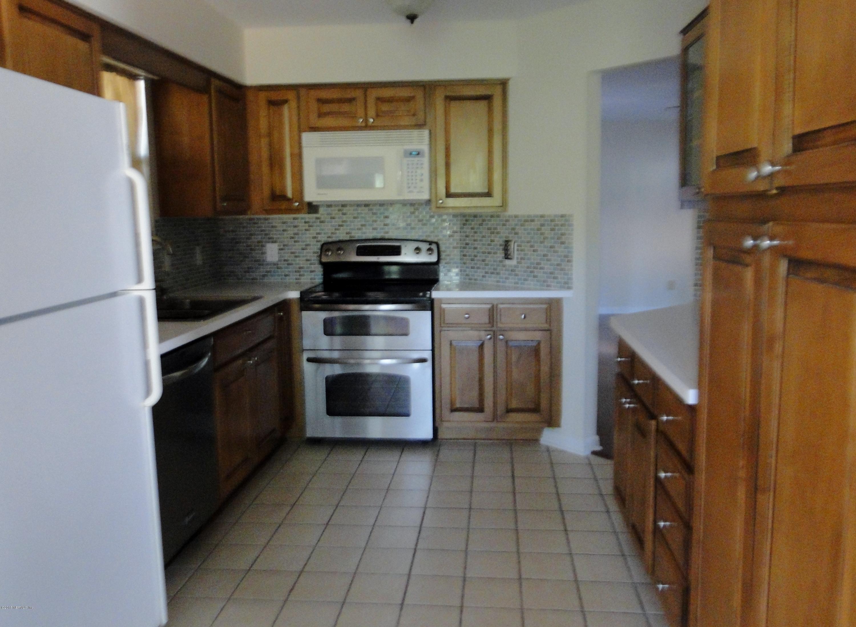 5496 Spring Brook Road Jacksonville, FL 32277 - Photo 7 of 25 a kitchen with a stove top oven and cabinets