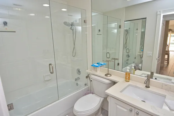 a bathroom with a sink toilet vanity and shower