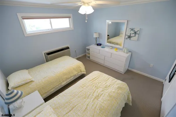 a bedroom with two beds and a flat screen tv