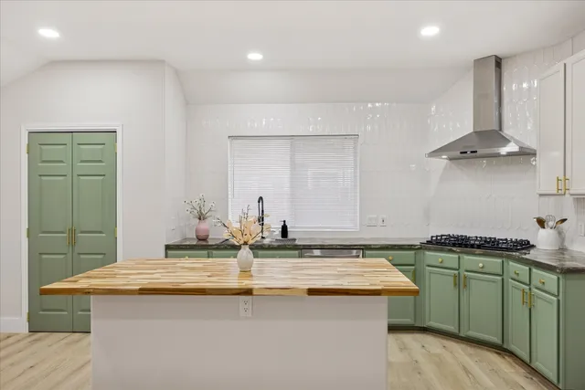 a kitchen with kitchen island a sink a stove and a refrigerator