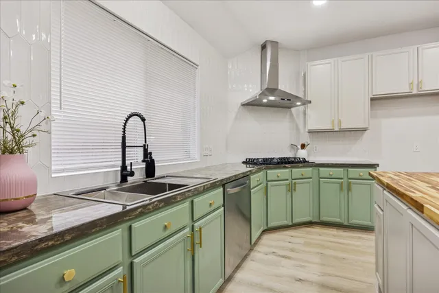 a kitchen with stainless steel appliances granite countertop a sink a stove and cabinets