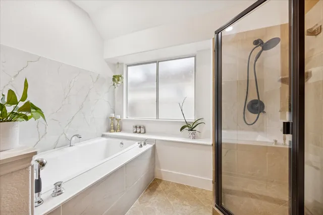 a bathroom with a tub a sink and mirror