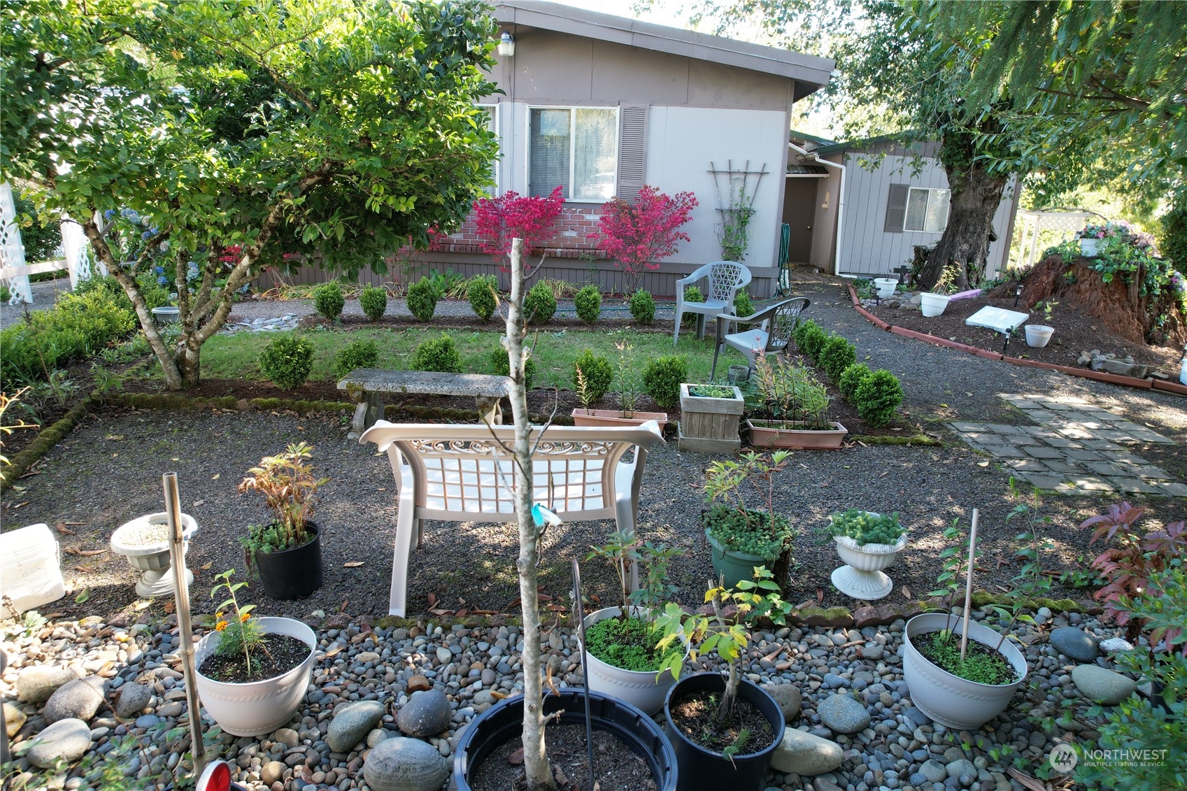 a view of a backyard with garden and sitting area