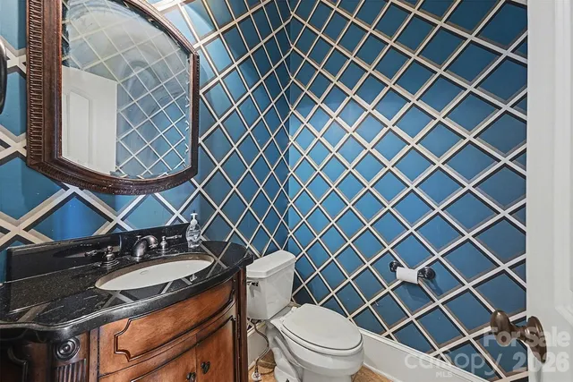a bathroom with a granite countertop toilet sink and mirror