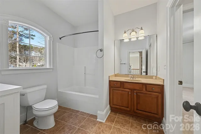 a spacious bathroom with a granite countertop sink a mirror a bathtub and shower