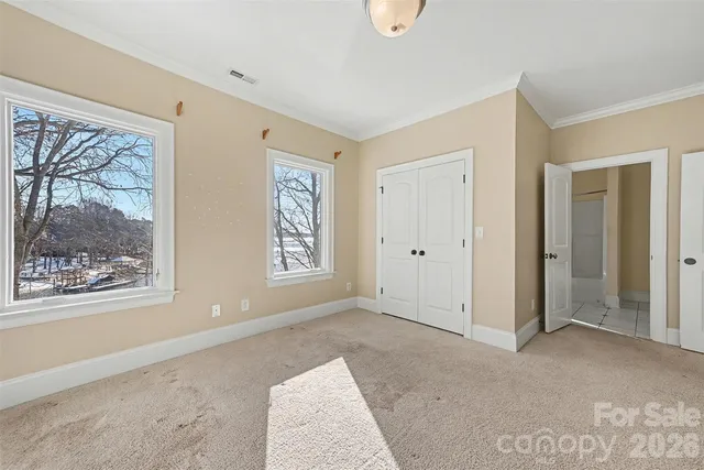 a view of a room with a ceiling fan and windows