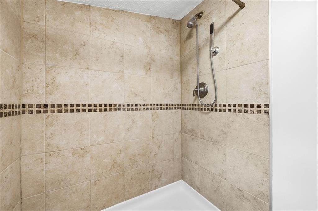 123 Cemetery Road Slippery Rock, PA 16057 - Photo 20 of 33 The tiled walk-in shower features neutral finishes, modern fixtures, and a decorative accent border for a clean, timeless look.