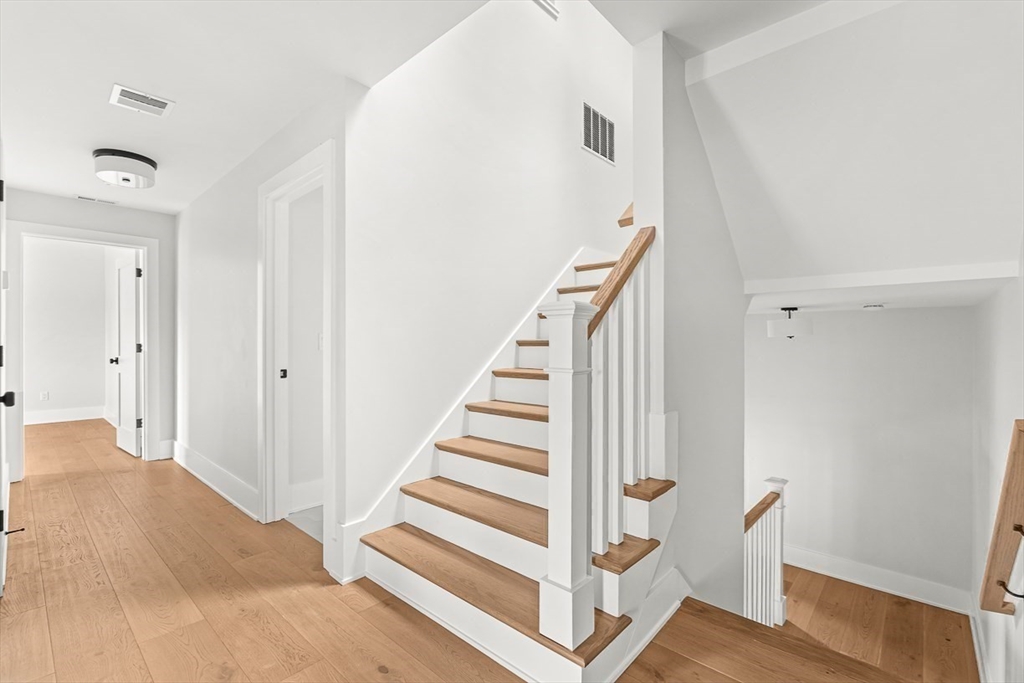 65 Summer Street, Unit 1 Natick, MA 01760 - Photo 18 of 21 a view of staircase with white walls and railing