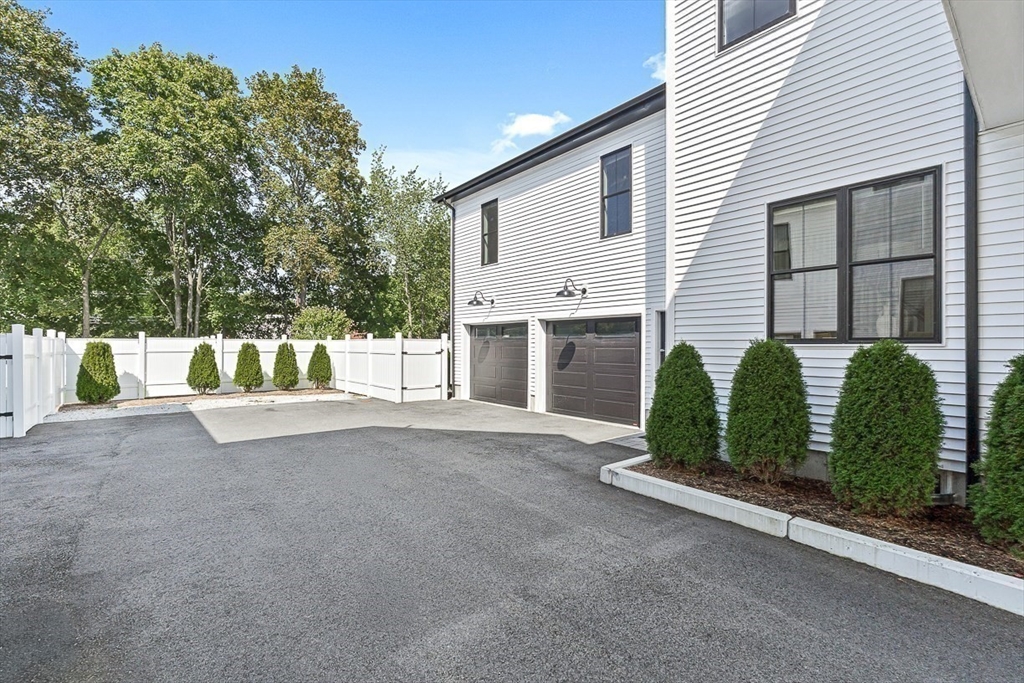 65 Summer Street, Unit 1 Natick, MA 01760 - Photo 21 of 21 a view of a house with garage and plants