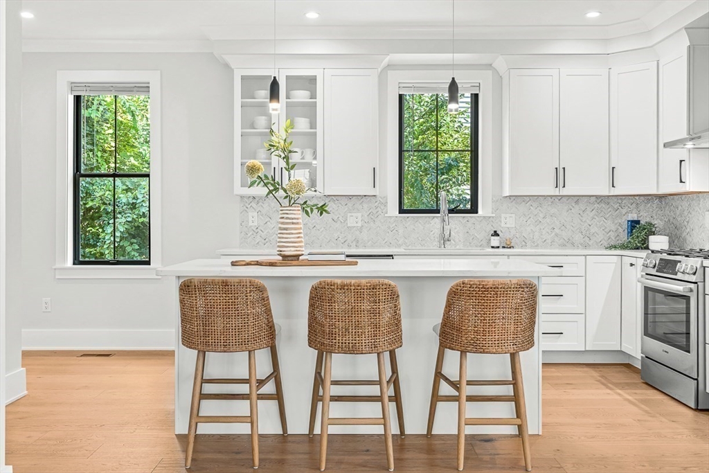 65 Summer Street, Unit 1 Natick, MA 01760 - Photo 4 of 21 a kitchen with a table chairs sink and cabinets