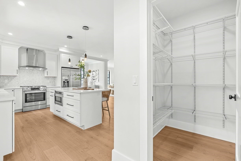 65 Summer Street, Unit 1 Natick, MA 01760 - Photo 6 of 21 a kitchen with white cabinets and stainless steel appliances