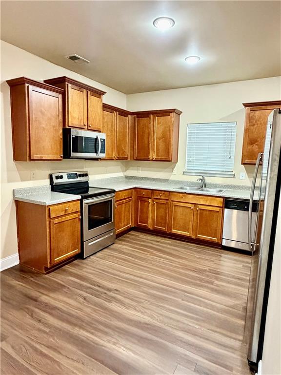 1985 Boatswain Drive Hampton, GA 30228 - Photo 4 of 14 a kitchen with stainless steel appliances granite countertop wooden cabinets a sink a stove a microwave a counter top and floors
