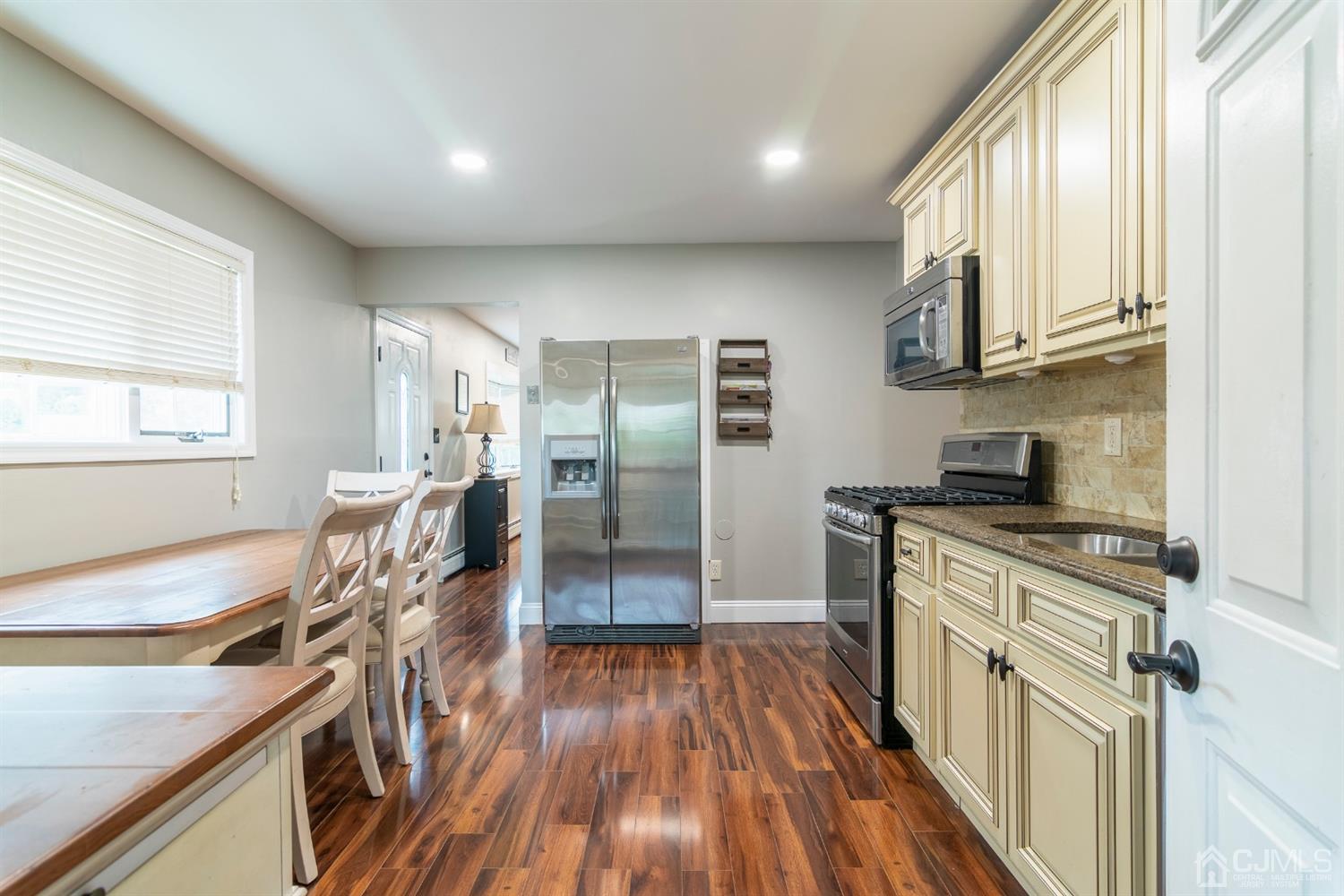 154 Winthrop Road Edison, NJ 08817 - Photo 7 of 18 a kitchen with stainless steel appliances granite countertop a refrigerator a sink dishwasher a stove and white countertops with wooden floor
