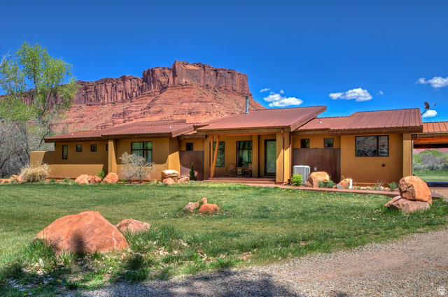 425 Amber Lane Moab, UT 84532 - Photo 23 of 27 View of front facade with stucco siding, a front yard, a metal roof, and a patio