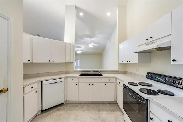 a kitchen with white cabinets and appliances