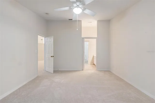 an empty room with a ceiling fan and window