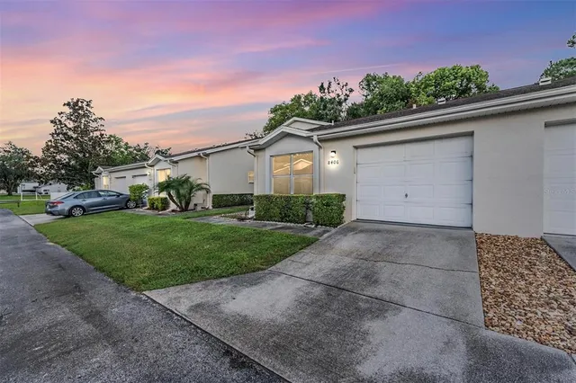 a view of a white house with a yard and potted plants