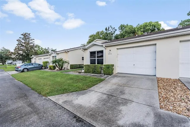 a front view of a house with a garden and trees