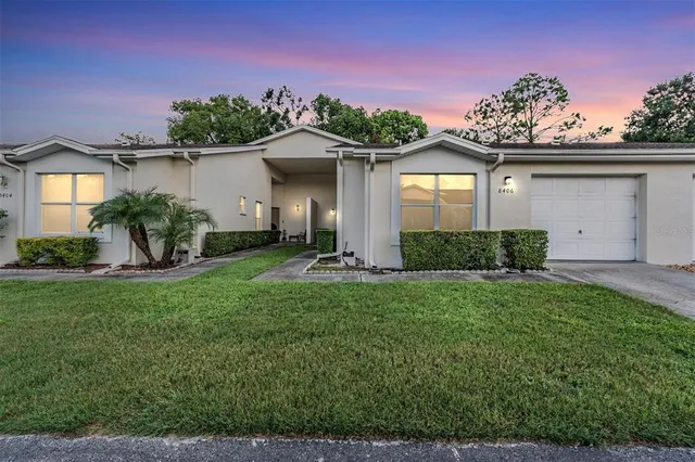 a front view of a house with a yard and potted plants